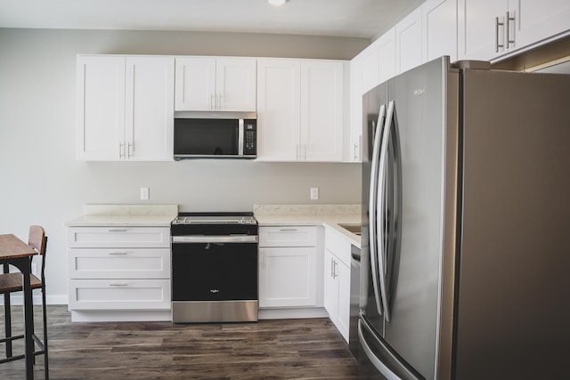 kitchen with dark hardwood / wood-style flooring, stainless steel appliances, and white cabinets