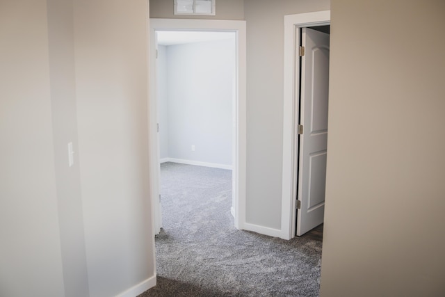 hallway featuring dark carpet