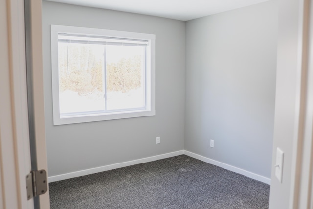 spare room with dark carpet