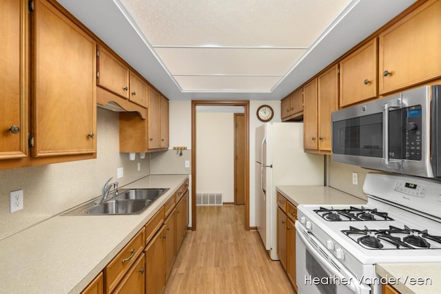 kitchen with sink, white range with gas stovetop, and light hardwood / wood-style floors