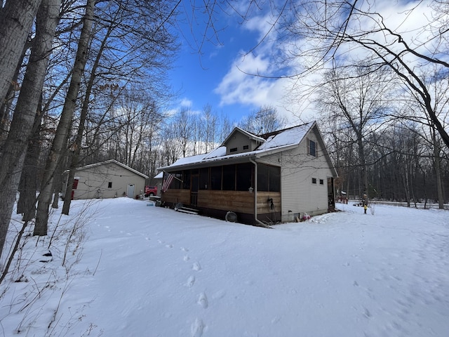 snow covered property with a sunroom