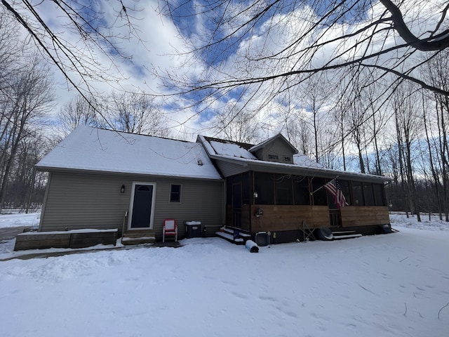 snow covered property featuring a sunroom