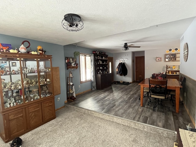 dining room featuring dark hardwood / wood-style flooring, ceiling fan, and a textured ceiling