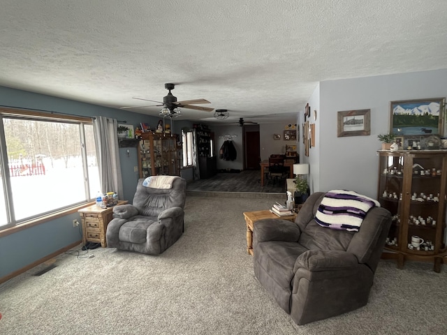 living room featuring ceiling fan, carpet floors, and a textured ceiling