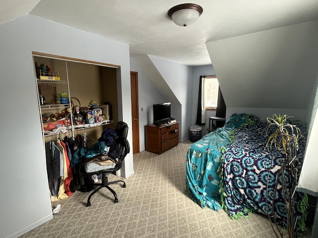 carpeted bedroom featuring lofted ceiling and a closet