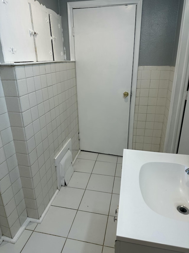 bathroom featuring vanity, tile patterned flooring, and tile walls