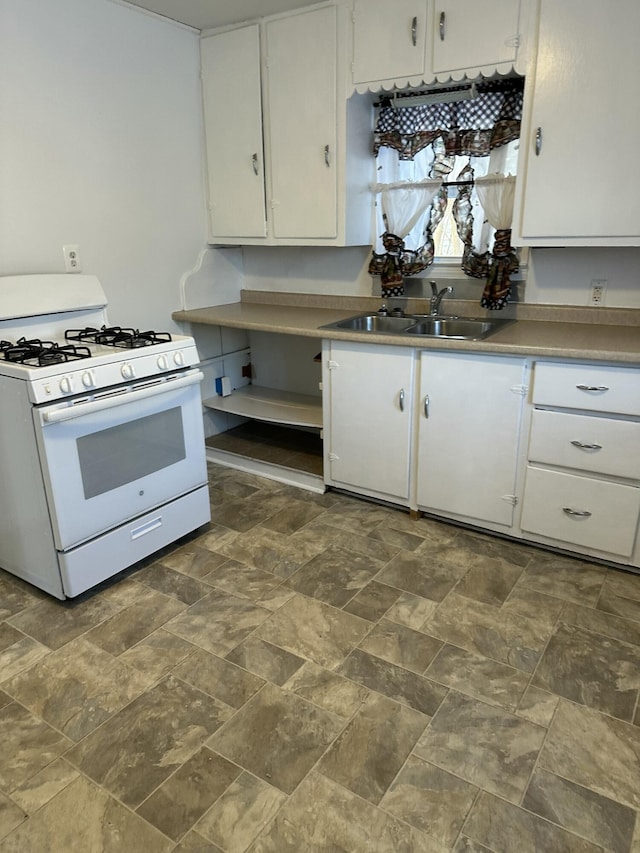 kitchen with white gas range, sink, and white cabinets