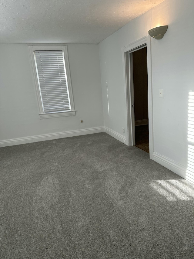 carpeted spare room with a textured ceiling