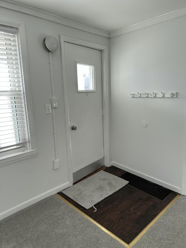 foyer entrance with ornamental molding and dark hardwood / wood-style flooring