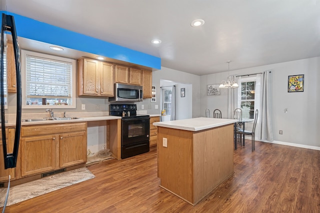 kitchen with a kitchen island, decorative light fixtures, sink, dark hardwood / wood-style flooring, and black electric range