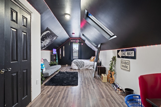 bedroom featuring wood-type flooring and vaulted ceiling with skylight