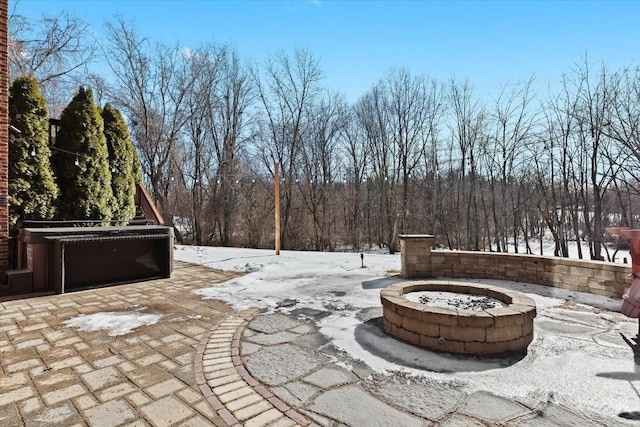 snow covered patio with a fire pit