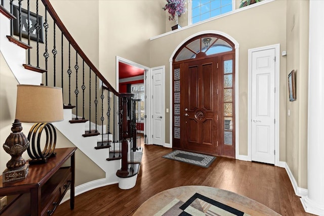 entryway featuring dark hardwood / wood-style floors and a towering ceiling