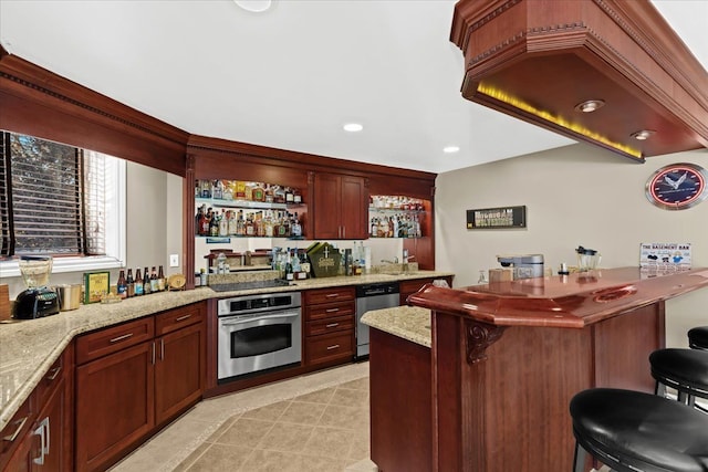 kitchen featuring light stone countertops, light tile patterned floors, stainless steel appliances, and a kitchen breakfast bar