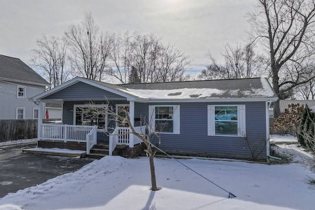 ranch-style home featuring roof with shingles and fence