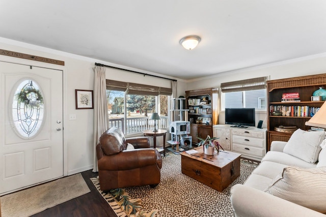 living area with baseboards, wood finished floors, and ornamental molding