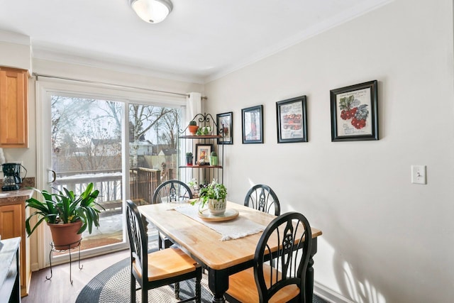 dining area featuring ornamental molding and wood finished floors