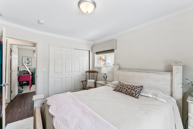 bedroom featuring ornamental molding, a closet, visible vents, and wood finished floors