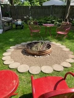 view of yard with an outdoor fire pit and fence