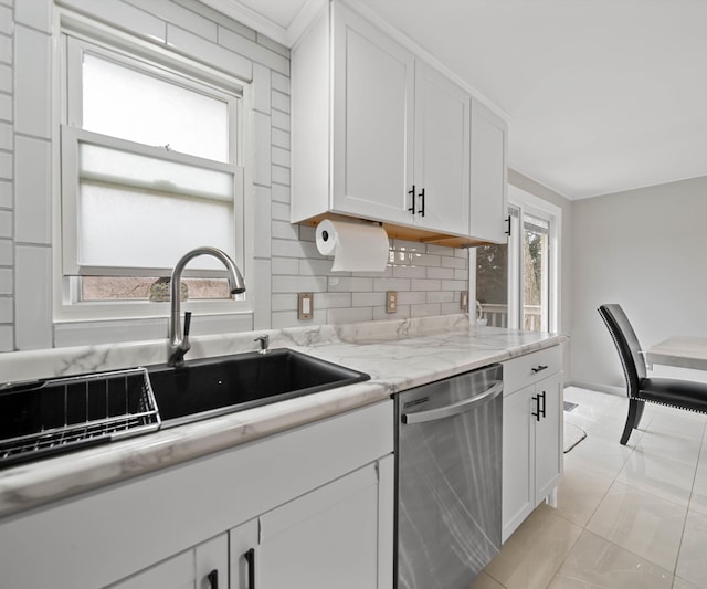 kitchen featuring stainless steel dishwasher, light stone countertops, sink, and white cabinets