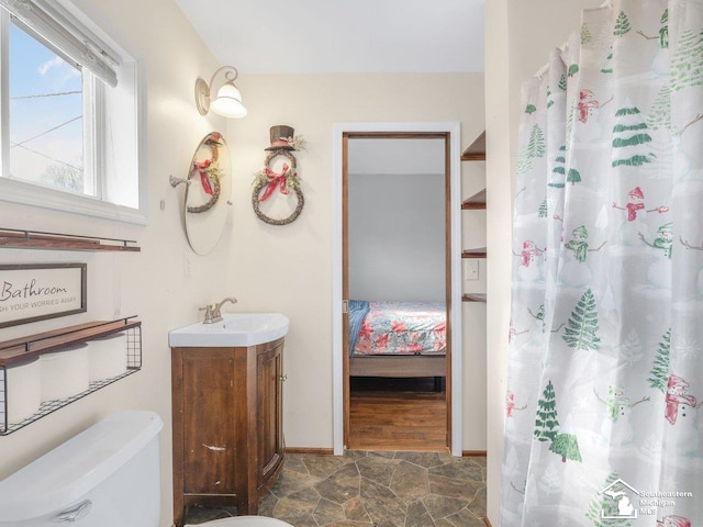 bathroom featuring vanity, curtained shower, and toilet