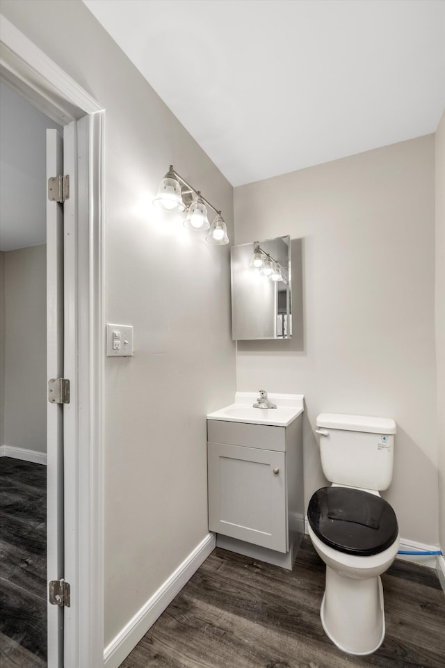 bathroom with wood-type flooring, vanity, and toilet