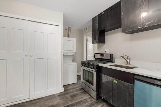 kitchen featuring dark hardwood / wood-style floors, sink, stacked washer / drying machine, stainless steel appliances, and light stone countertops