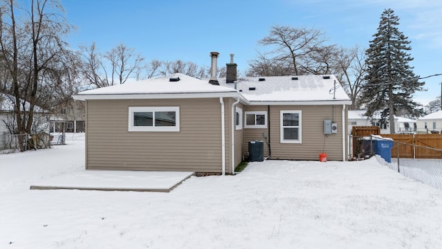 snow covered house with central air condition unit