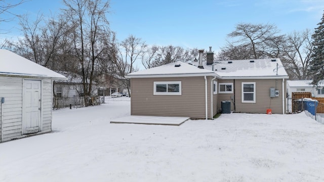 snow covered house featuring central air condition unit