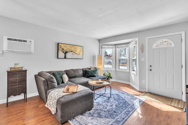 living room featuring hardwood / wood-style flooring and a wall mounted air conditioner