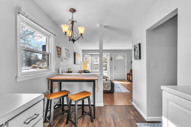 kitchen featuring pendant lighting, a notable chandelier, dark hardwood / wood-style floors, and an AC wall unit