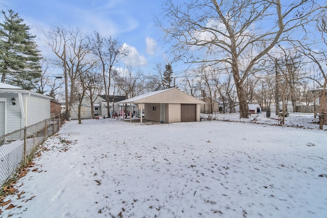 snowy yard with an outbuilding and a garage