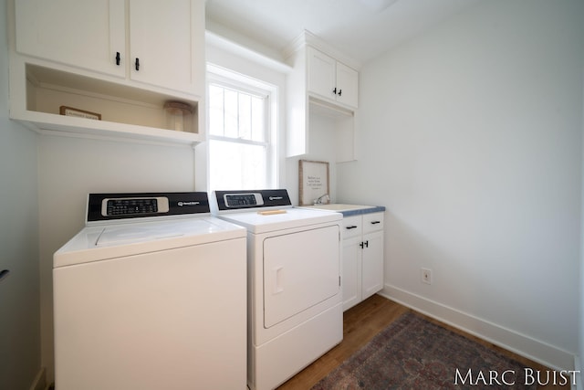 laundry area featuring cabinets, dark wood-type flooring, sink, and washer and clothes dryer