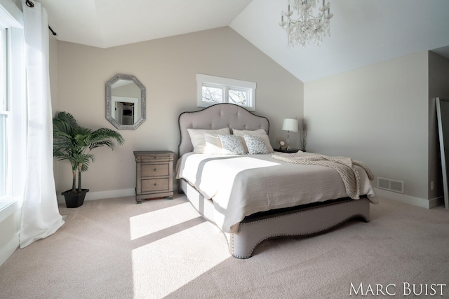 carpeted bedroom with lofted ceiling and a notable chandelier