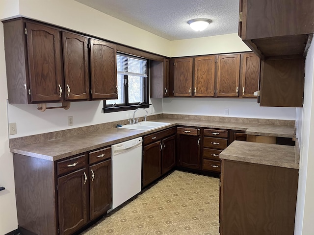 kitchen with dark brown cabinetry, dishwasher, and sink