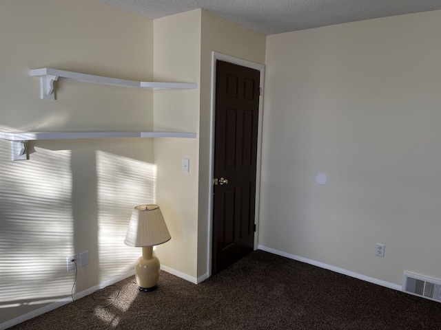 carpeted empty room featuring a textured ceiling