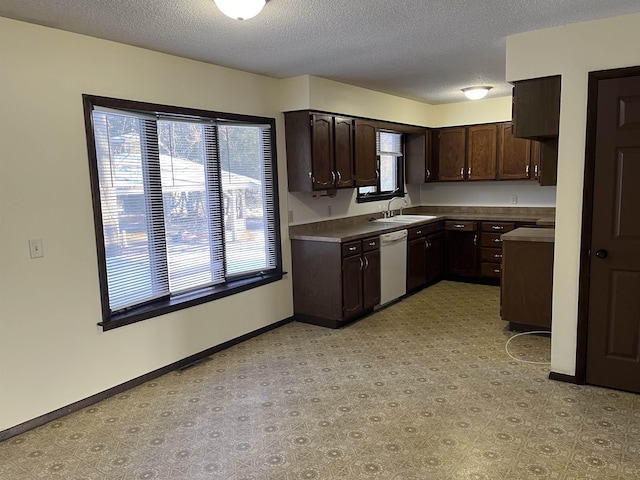 kitchen with dishwasher, sink, a textured ceiling, and dark brown cabinetry