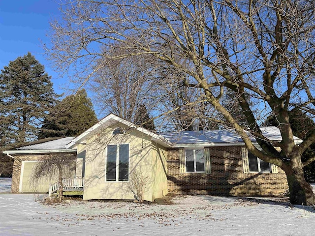 view of snow covered exterior featuring a garage