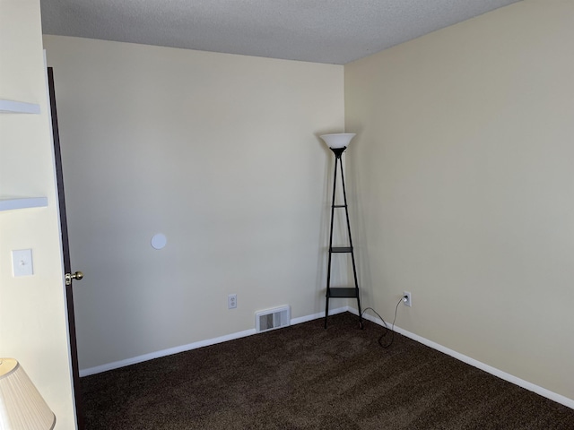 carpeted empty room featuring a textured ceiling