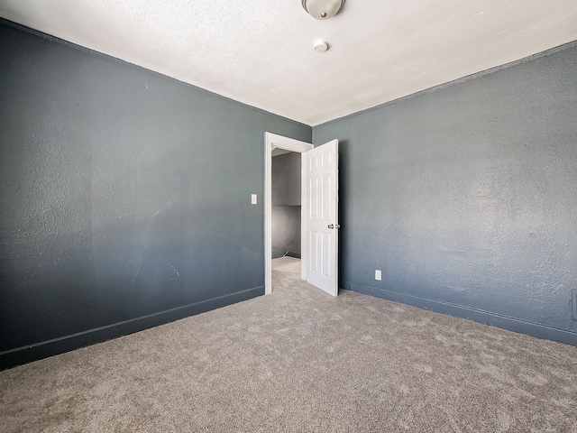 unfurnished room with carpet flooring and a textured ceiling