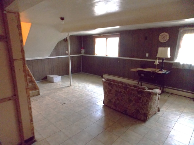 living room with wooden walls, tile patterned floors, baseboard heating, and lofted ceiling