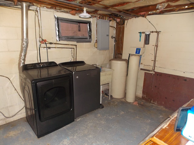 unfinished below grade area with concrete block wall, separate washer and dryer, and electric panel
