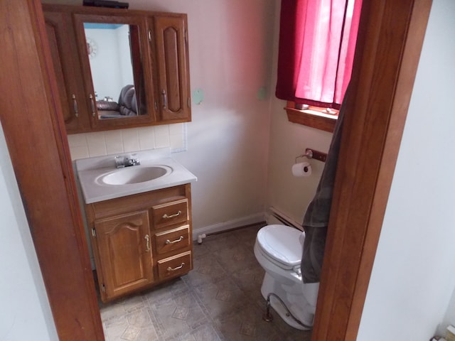 half bathroom with toilet, a baseboard radiator, and vanity