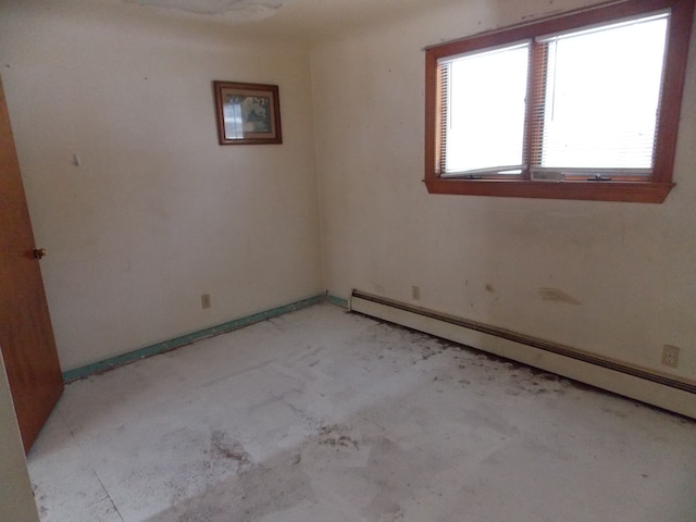 empty room featuring a baseboard heating unit and baseboards