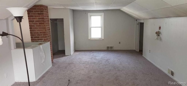 bonus room featuring light colored carpet, washer / clothes dryer, and vaulted ceiling