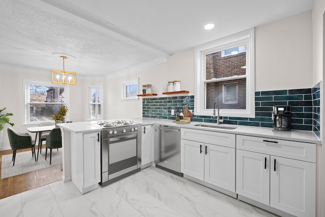 kitchen with sink, stainless steel appliances, kitchen peninsula, and white cabinets