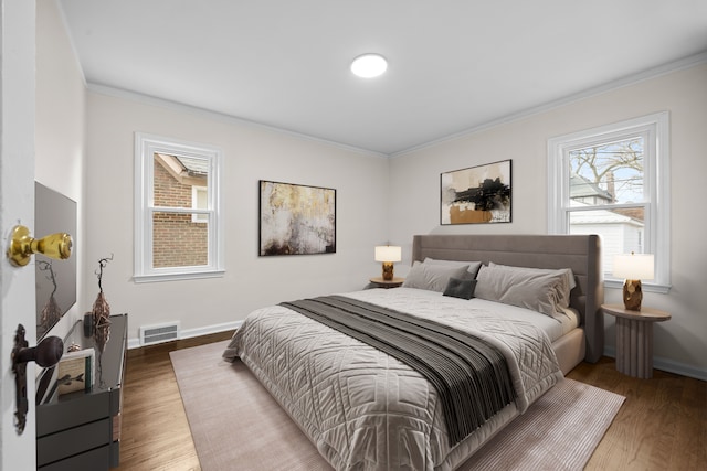 bedroom featuring multiple windows, crown molding, and dark hardwood / wood-style flooring