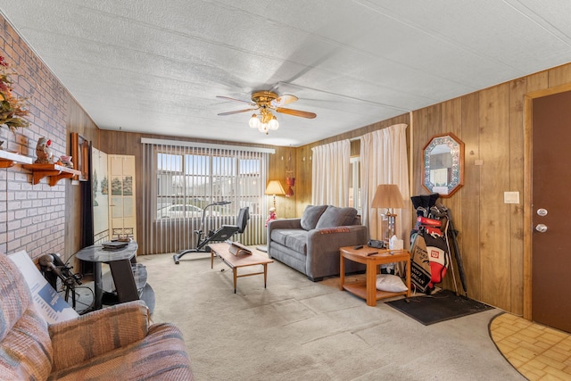 carpeted living room featuring ceiling fan, wooden walls, and a textured ceiling