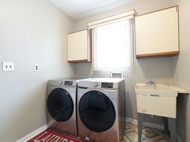 washroom featuring sink, cabinets, and independent washer and dryer