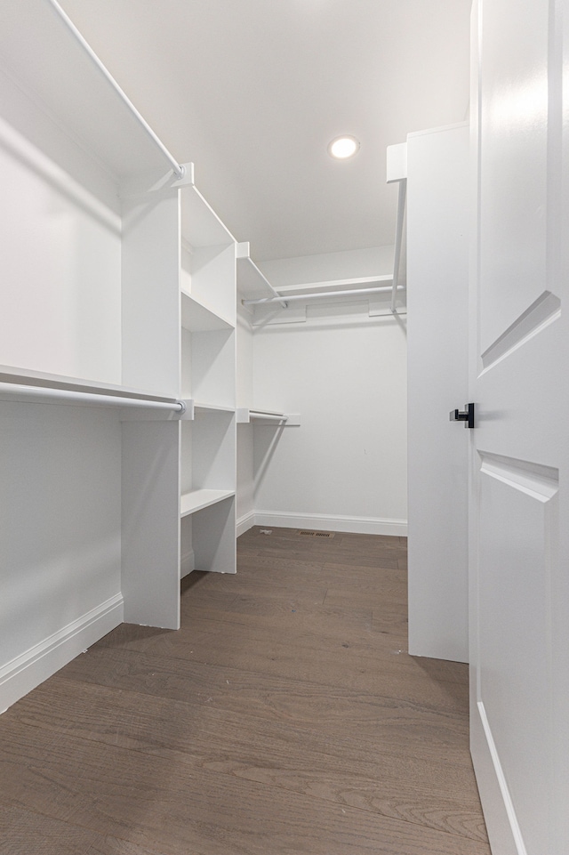 walk in closet with dark wood-type flooring